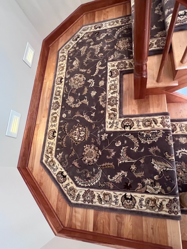Oriental runner on hardwood stair landing. 